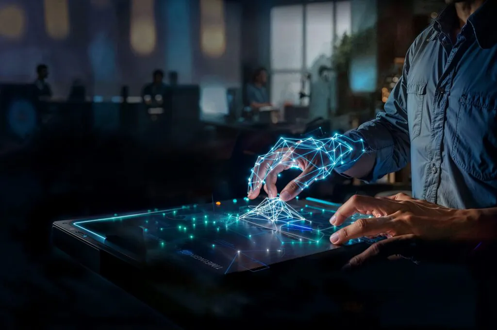 Een persoon manipuleert een gloeiend, digitaal netwerkmodel op een interactieve tafel in een kantooromgeving, wat moderne sap fsm-technologie voor efficiënt asset management en procesoptimalisatie visualiseert.