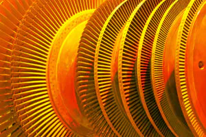 Een industriële turbine met talrijke metalen schoepen draait rond in een machinekamer, wat essentieel is voor effectief asset management binnen grote energiecentrales.