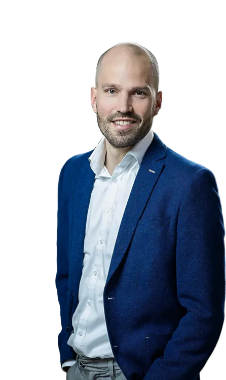 Een professionele man met een geschoren hoofd en baard glimlacht naar de camera, gekleed in een blauwe blazer en wit overhemd, als specialist in SAP FSM tegen een witte achtergrond.