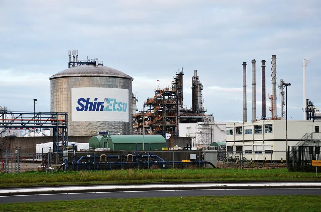 Een Shin-Etsu-opslagtank en industriële installaties torenen boven een fabrieksterrein uit, waarbij efficiënt asset management en geavanceerde SAP technology bijdragen aan de operationele processen op deze locatie.